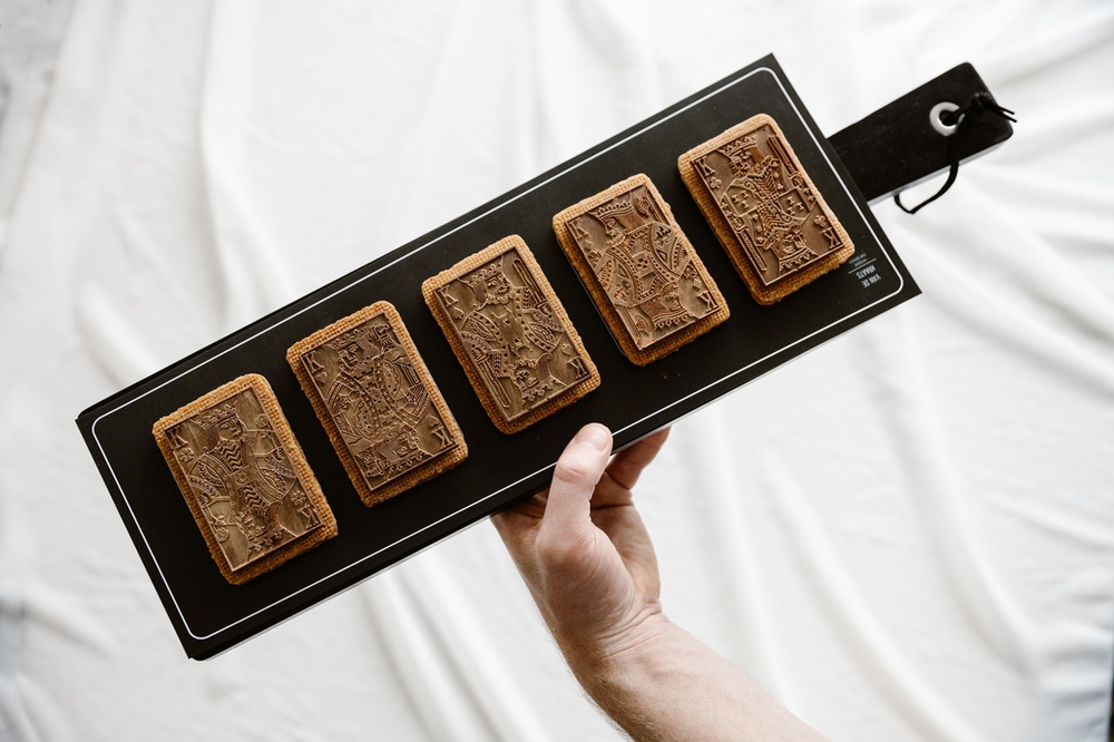 Vijf rechthoekige koekjes met in chocolade vijf verschillende heren - zoals op speelkaarten
