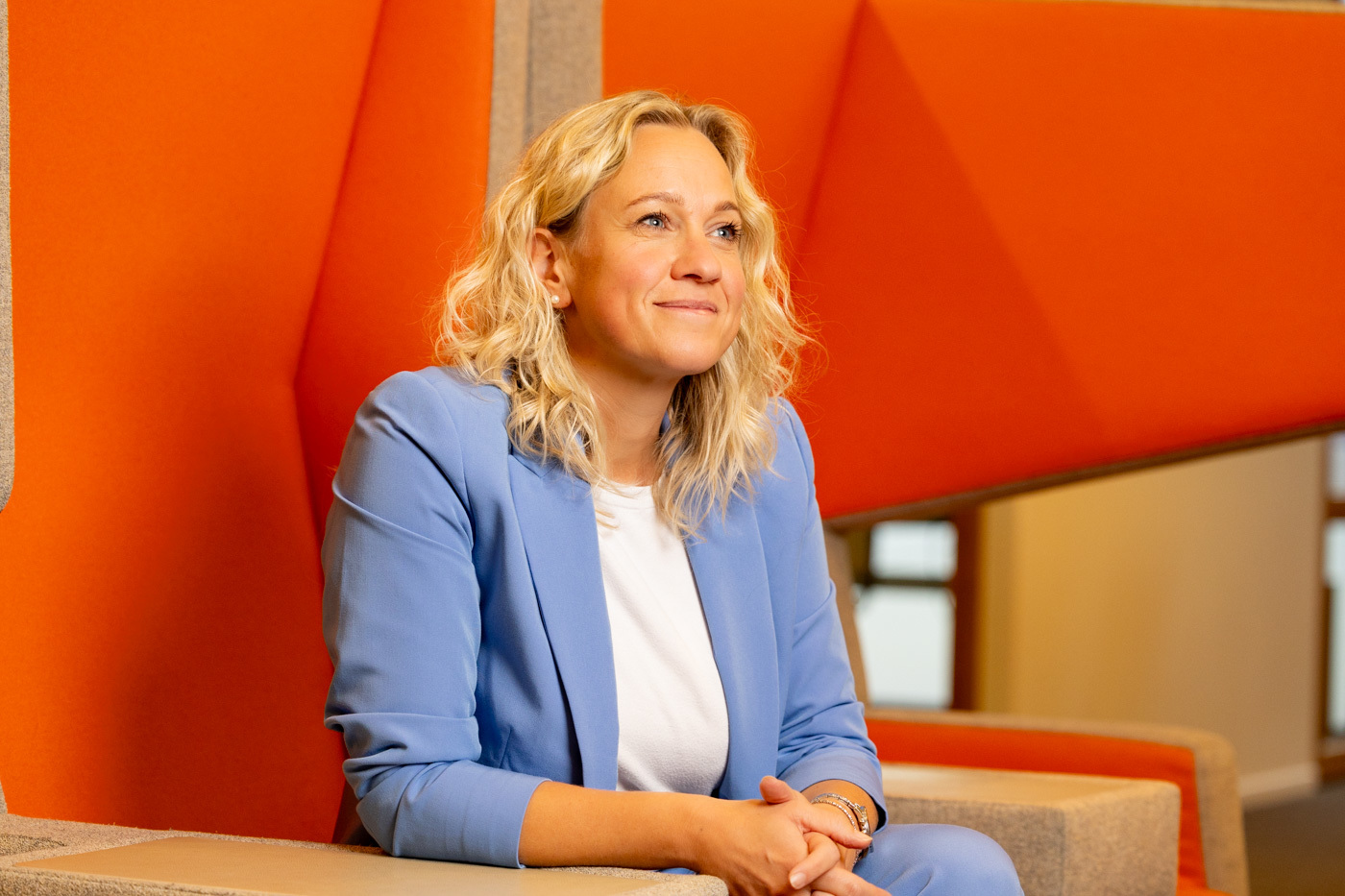 Foto van Leonie, zittend in een oranje bank